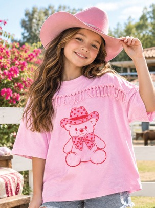Niña con sombrero rosa y playera rosa con osito vaquero y flecos